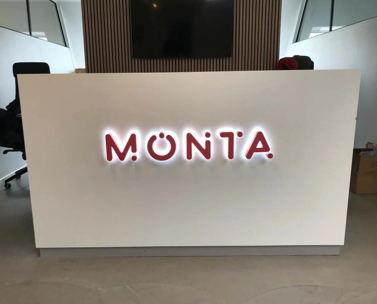 Frontlyste kanalbogstaver på receptionsvæg hos Monta
