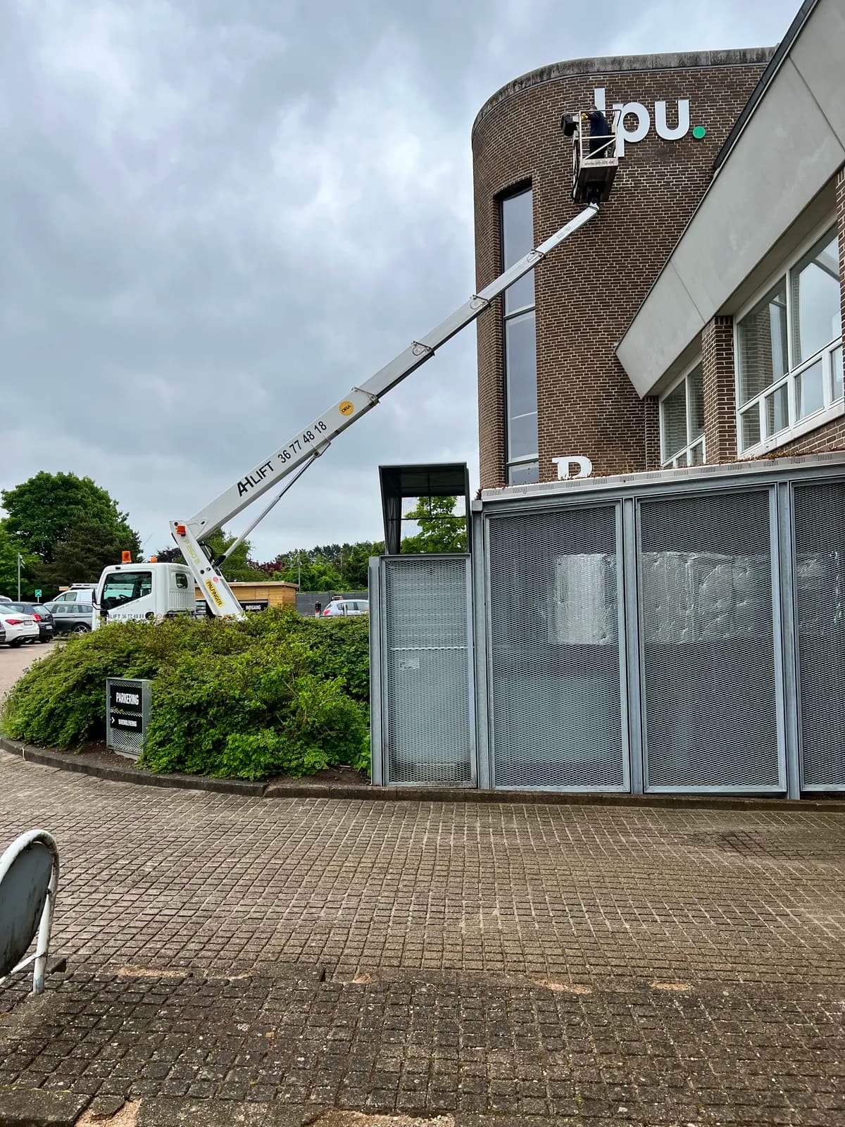 Montage af facadebogstaver fra lift på murstensfacade