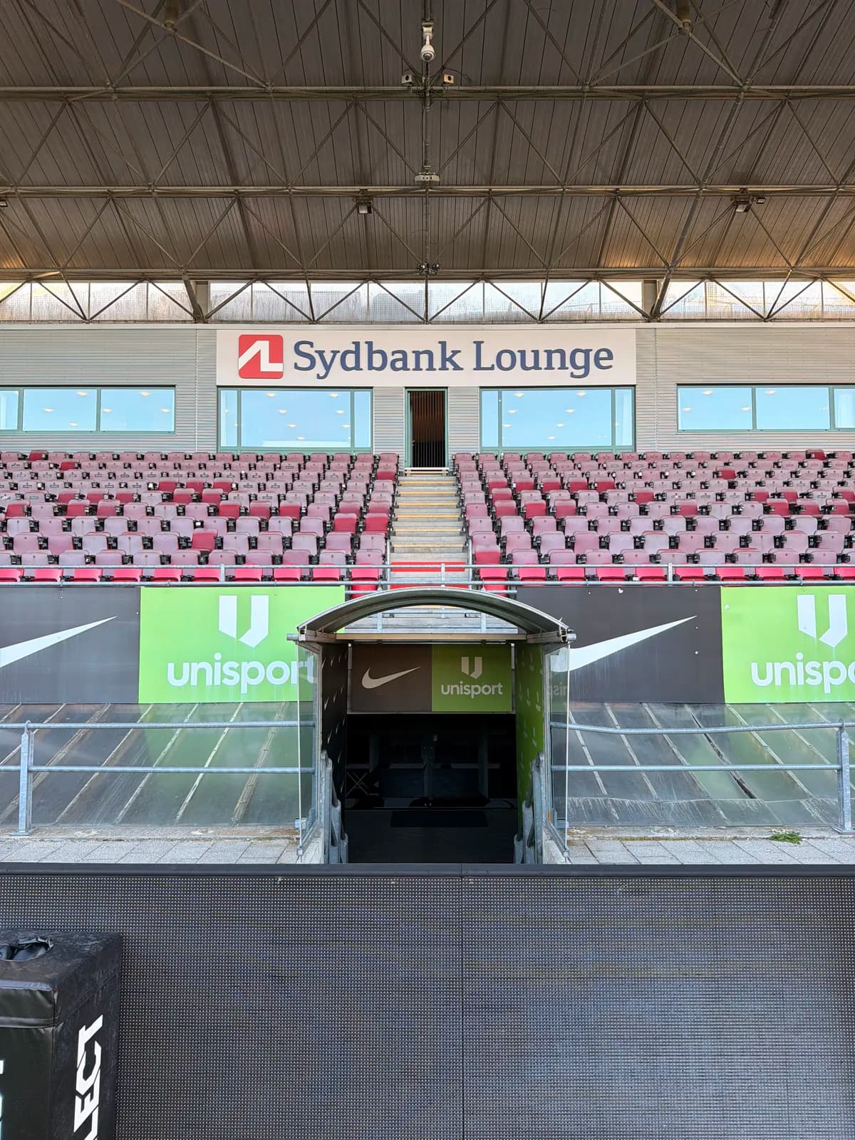 Facadeskilt til Sydbank Lounge monteret over tribunesæderne på stadion