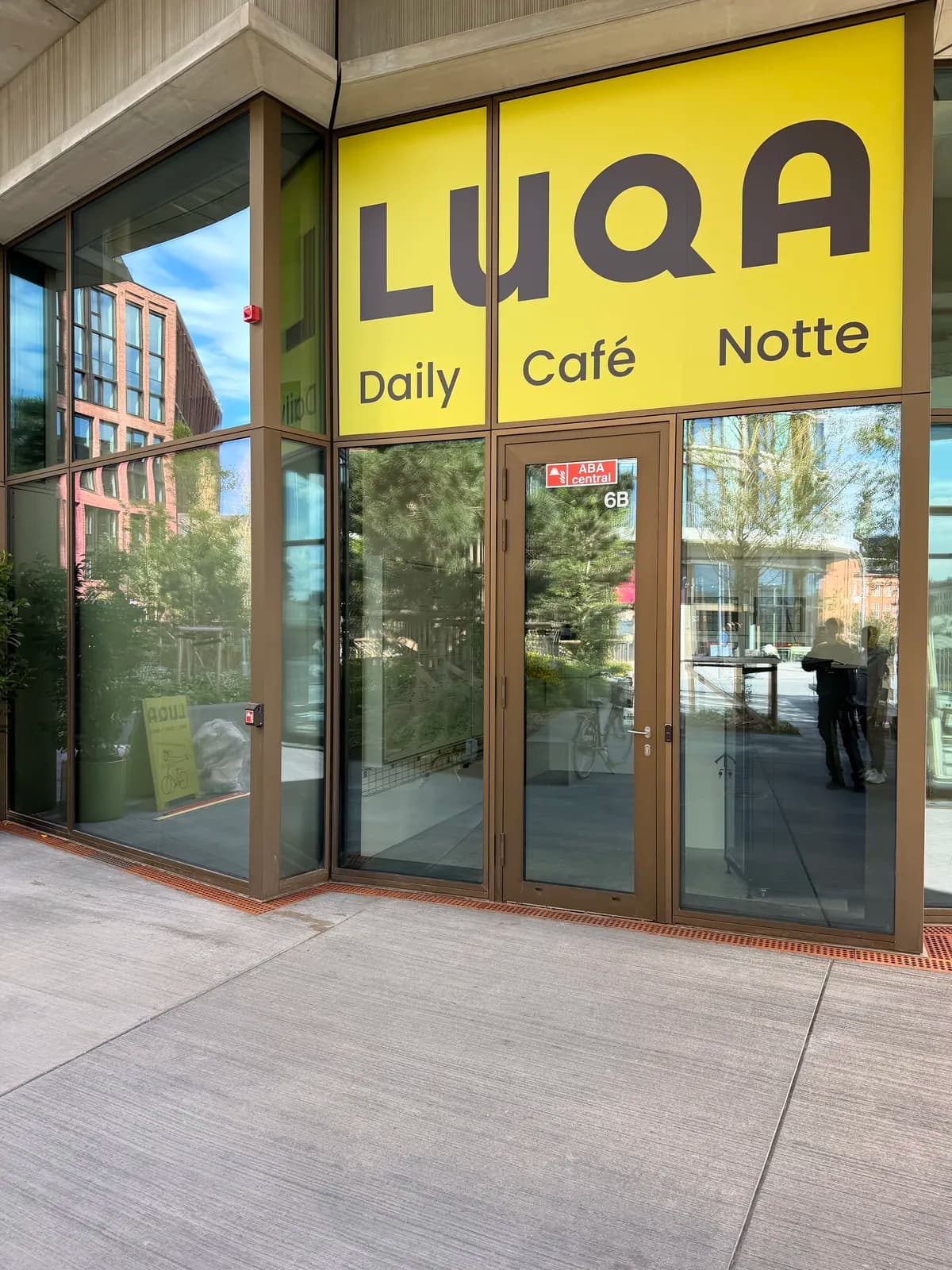 Gul folie med logo til LUQA café monteret på glasfacaden