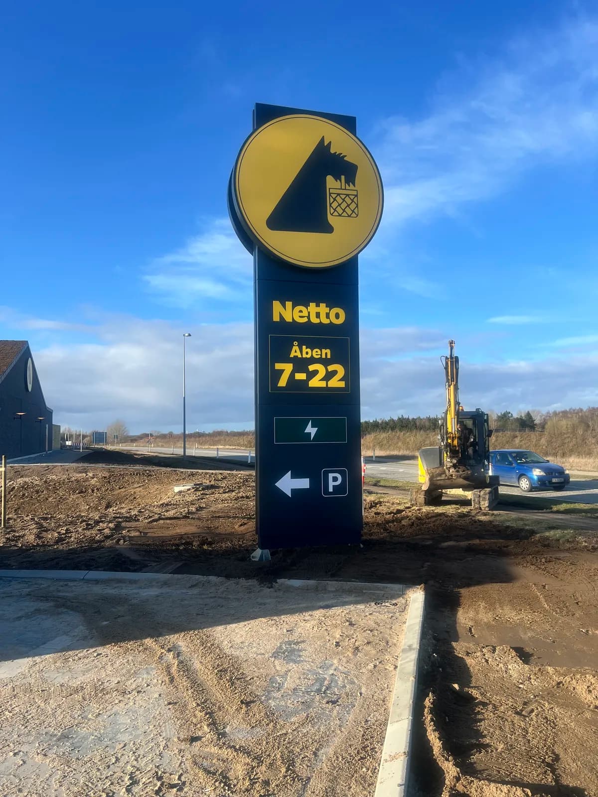 Pylon med logo og henvisningsskilte til Netto ved nyopført butik