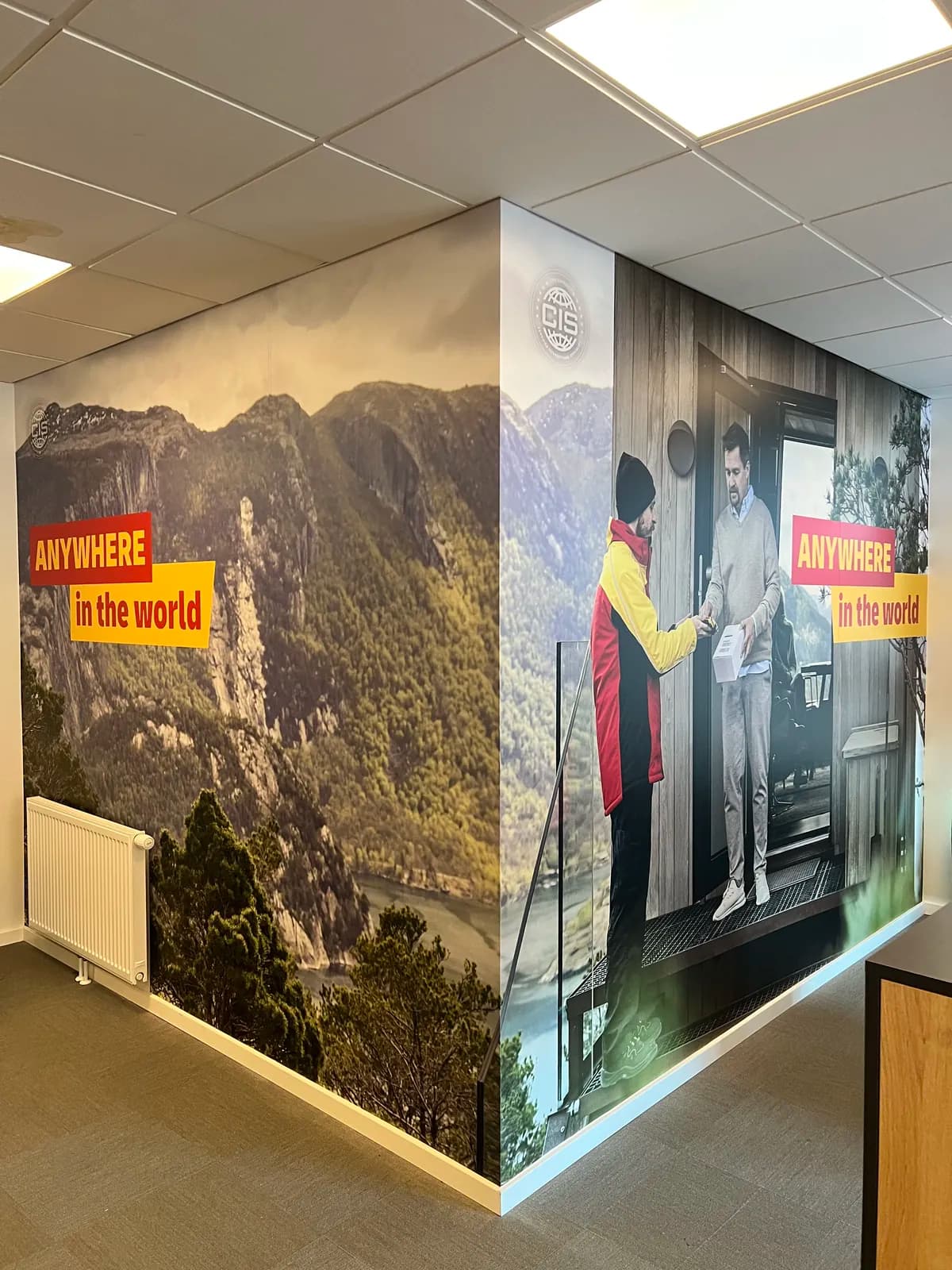 Vægfolie med Anywhere in the world-motiv monteret hen over hjørne i kontor hos DHL