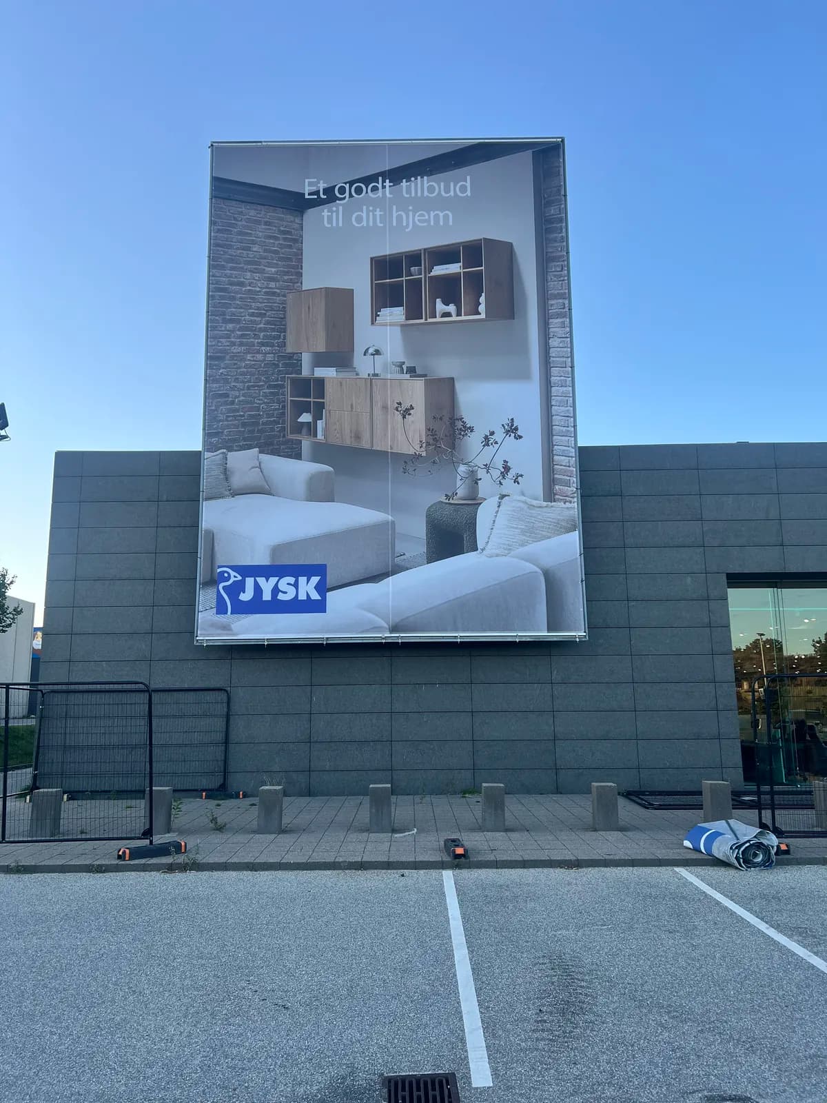 Stort reklamebanner i bannerramme monteret ved butiksfacade for JYSK
