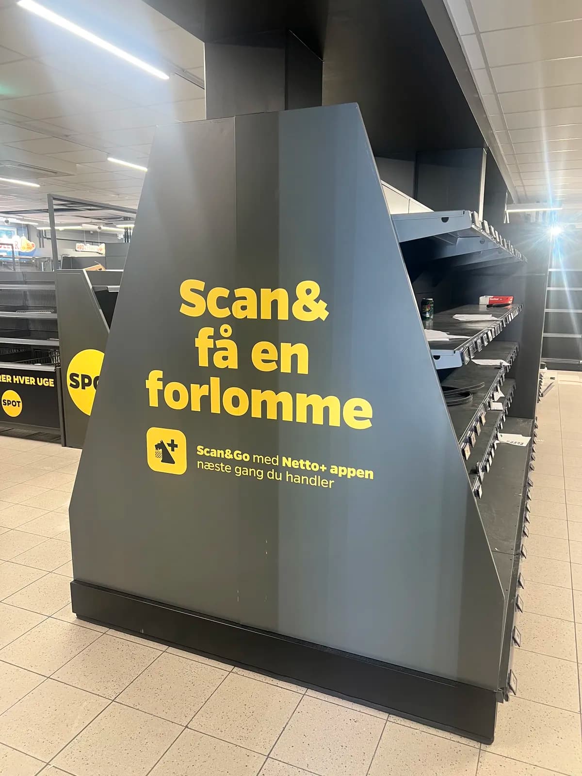 Foliedekoration med Scan&Go-grafik til Netto+ appen på butiksinventar hos Netto