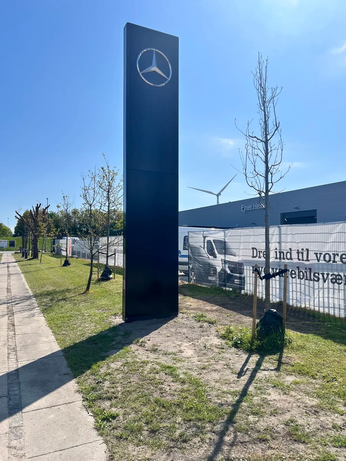 Fritstående sort pylon med Mercedes-Benz-stjerne opsat foran forhandler