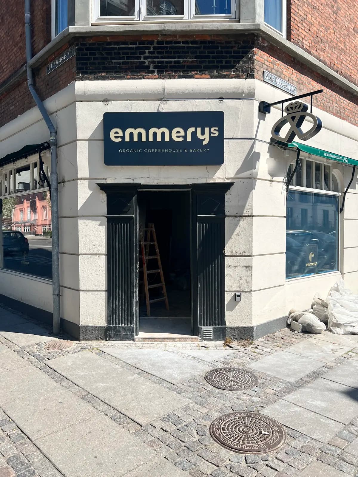 Facadeskilt og udhængsskilt med kringle til emmerys organic coffeehouse & bakery på klassisk byfacade