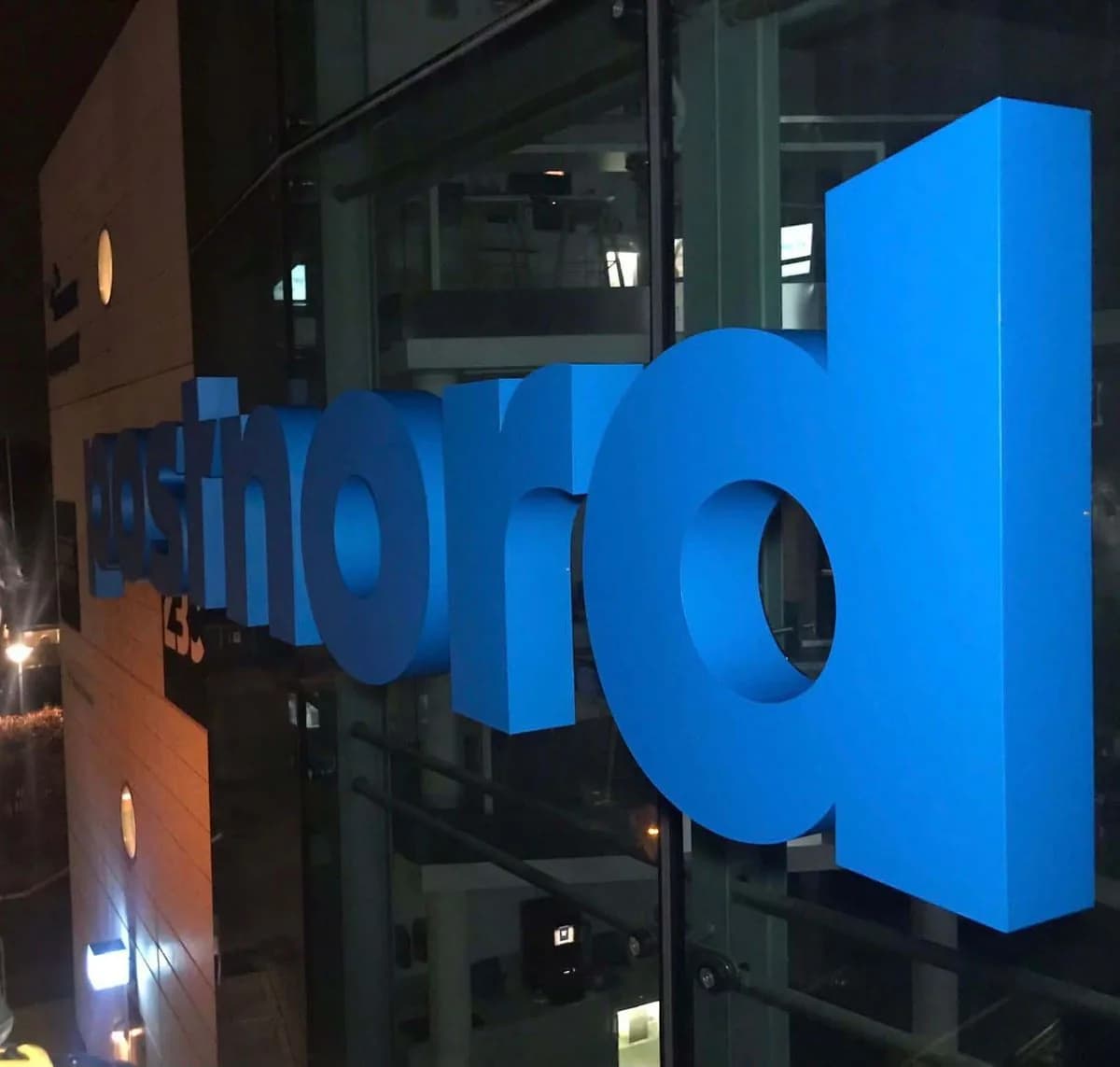 Belyste facadebogstaver til PostNord fotograferet i mørke