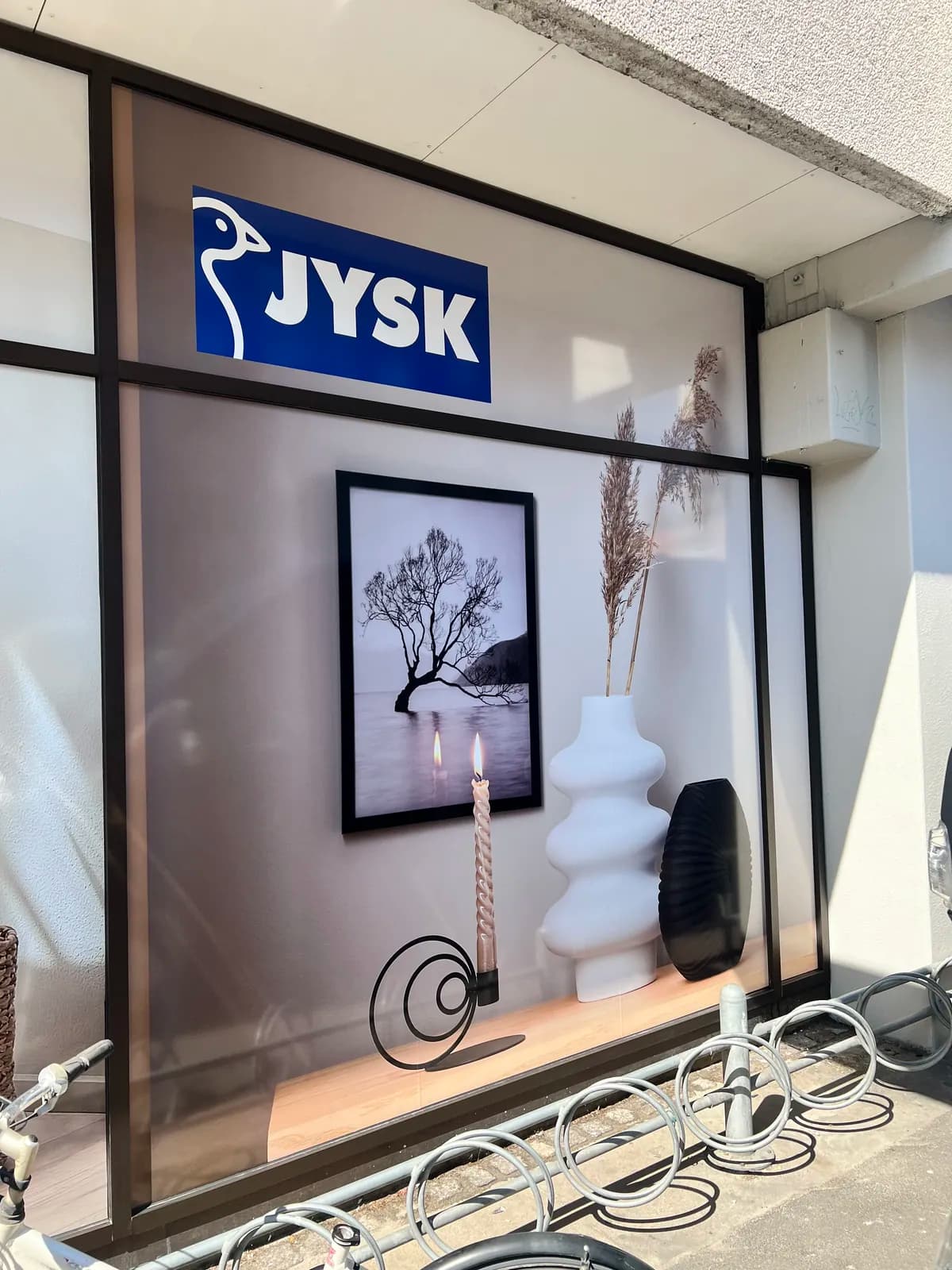 Printet vinduesfolie med interiørmotiv og JYSK-logo monteret i butiksvindue