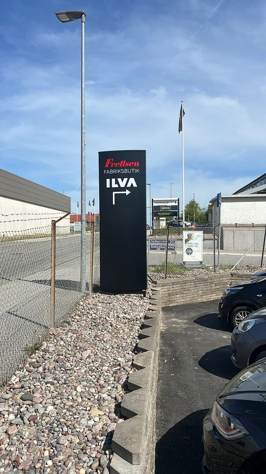 Sort pylon med henvisning til Frellsen Fabriksbutik og ILVA ved indkørslen