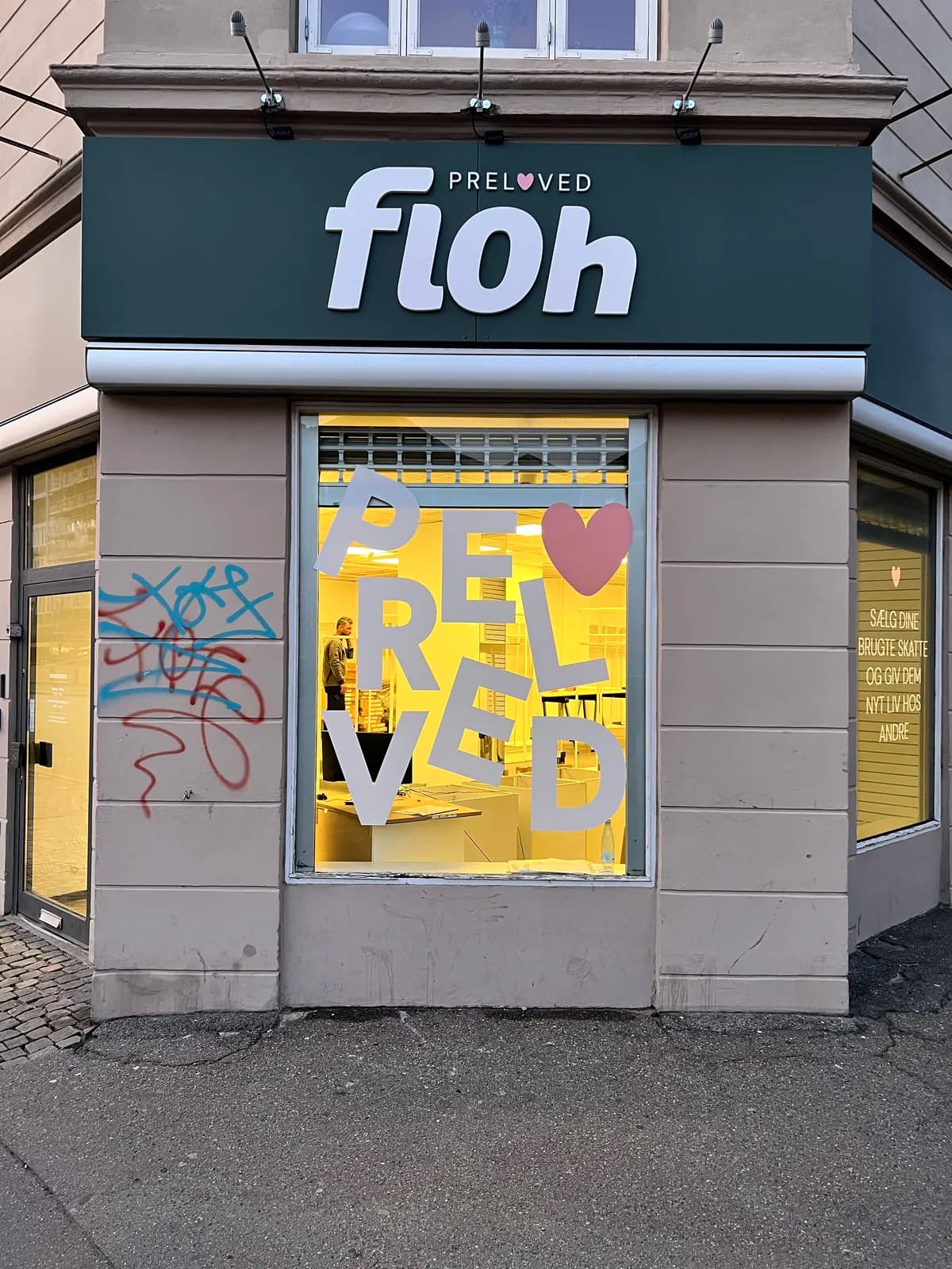 Facadeskilt med 3D-bogstaver til floh preloved samt bogstaver i vinduet, fotograferet i aftenlys