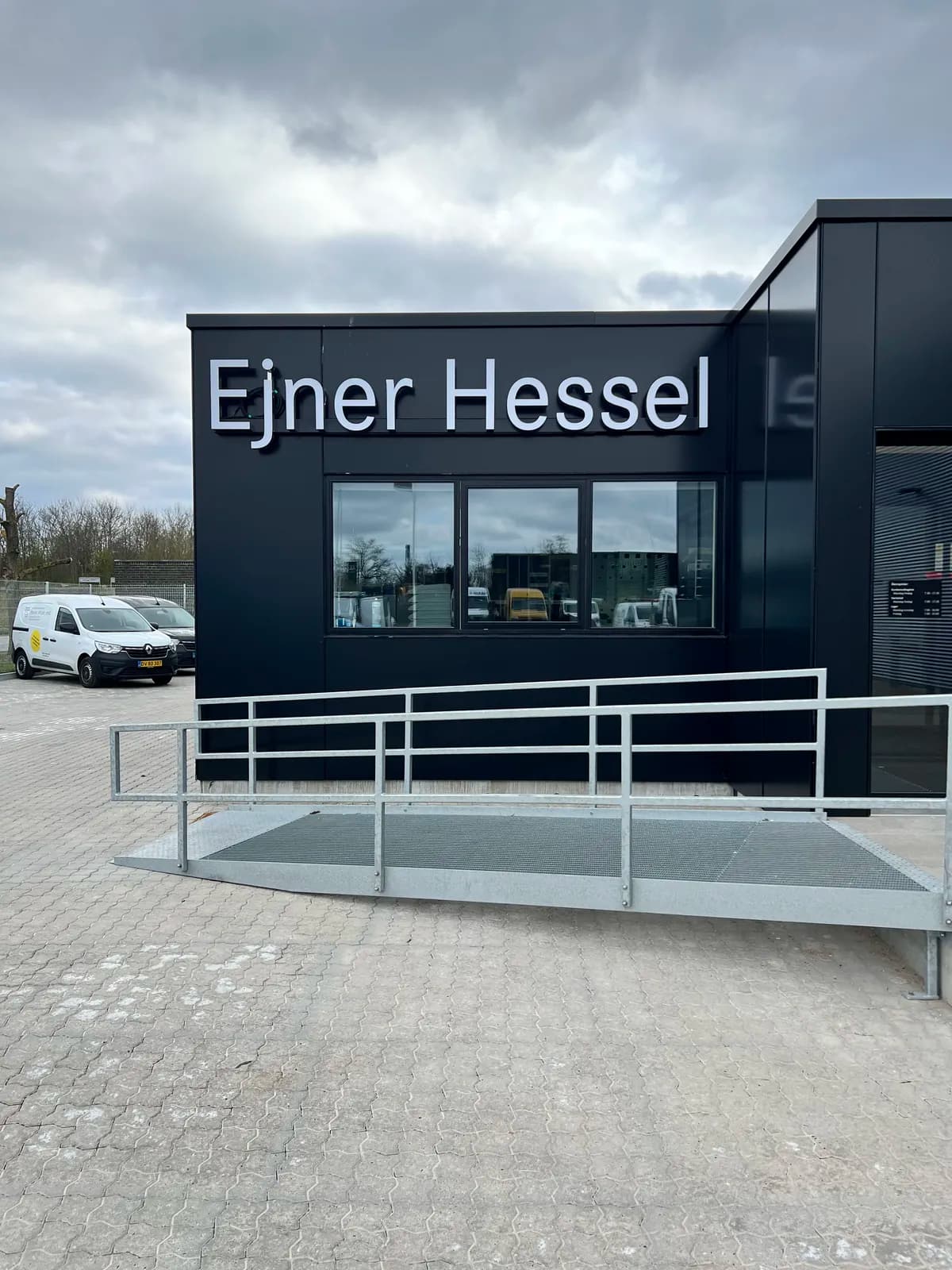 Hvide facadebogstaver monteret på sort indgangsparti hos Ejner Hessel