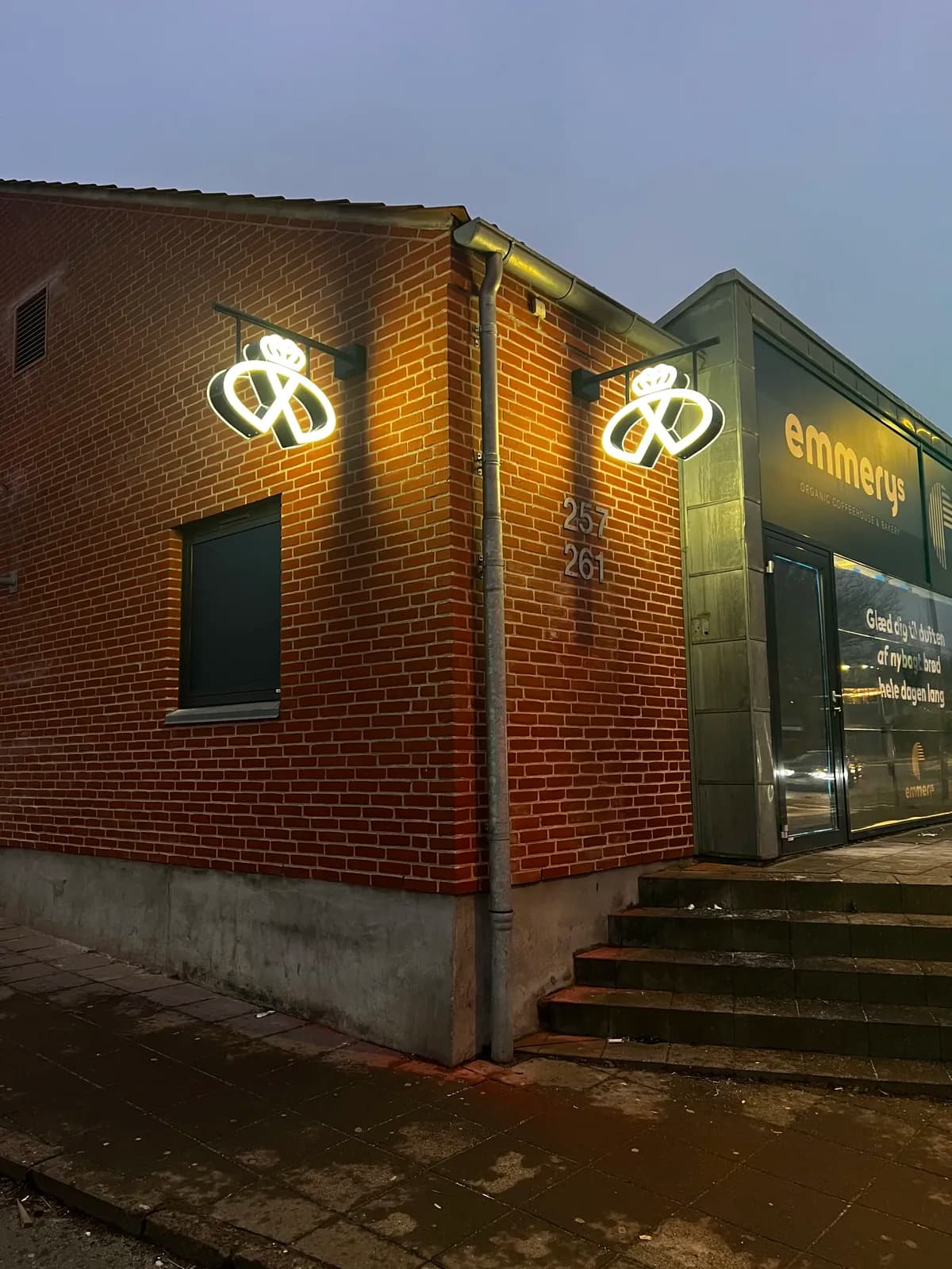 LED-neon udhængsskilte med Emmerys' kringlelogo oplyst i skumringen