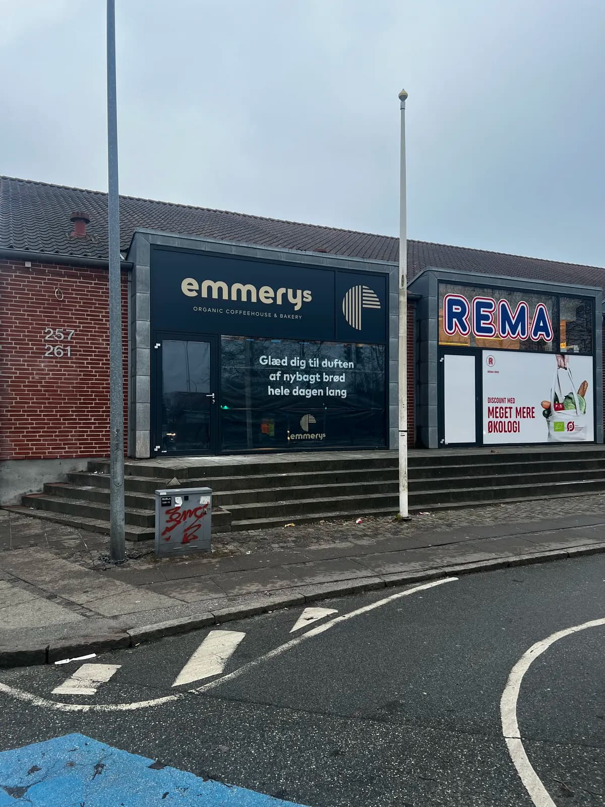 Facadeskilt med logo og vinduesfolie til Emmerys ved siden af REMA 1000