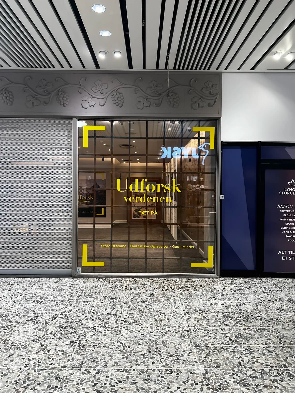 Gul dekorationsfolie til JYSK monteret på glasparti i Lyngby Storcenter