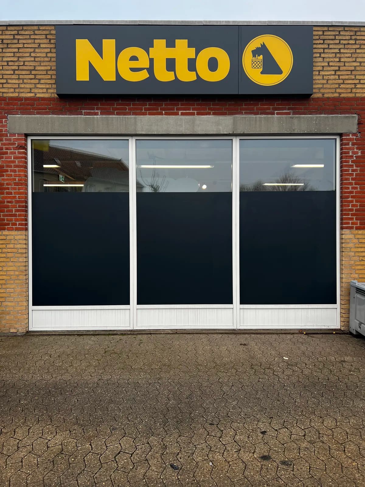 Afblænding med mørk folie i vinduespartier hos Netto