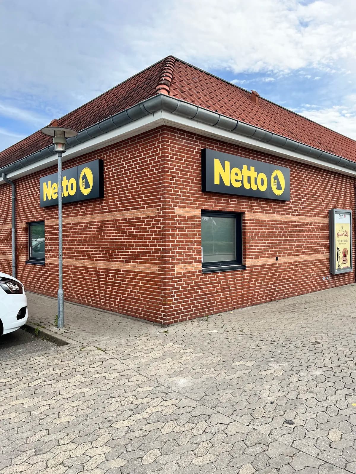 Facadeskilte til Netto monteret på hjørnet af murstensbygning