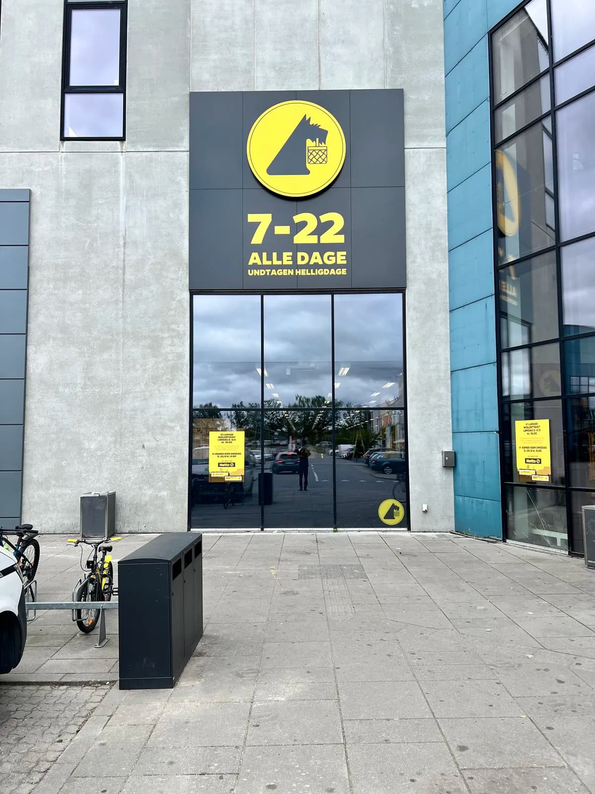 Facadeskilt med logo og åbningstider ved indgangen til Netto