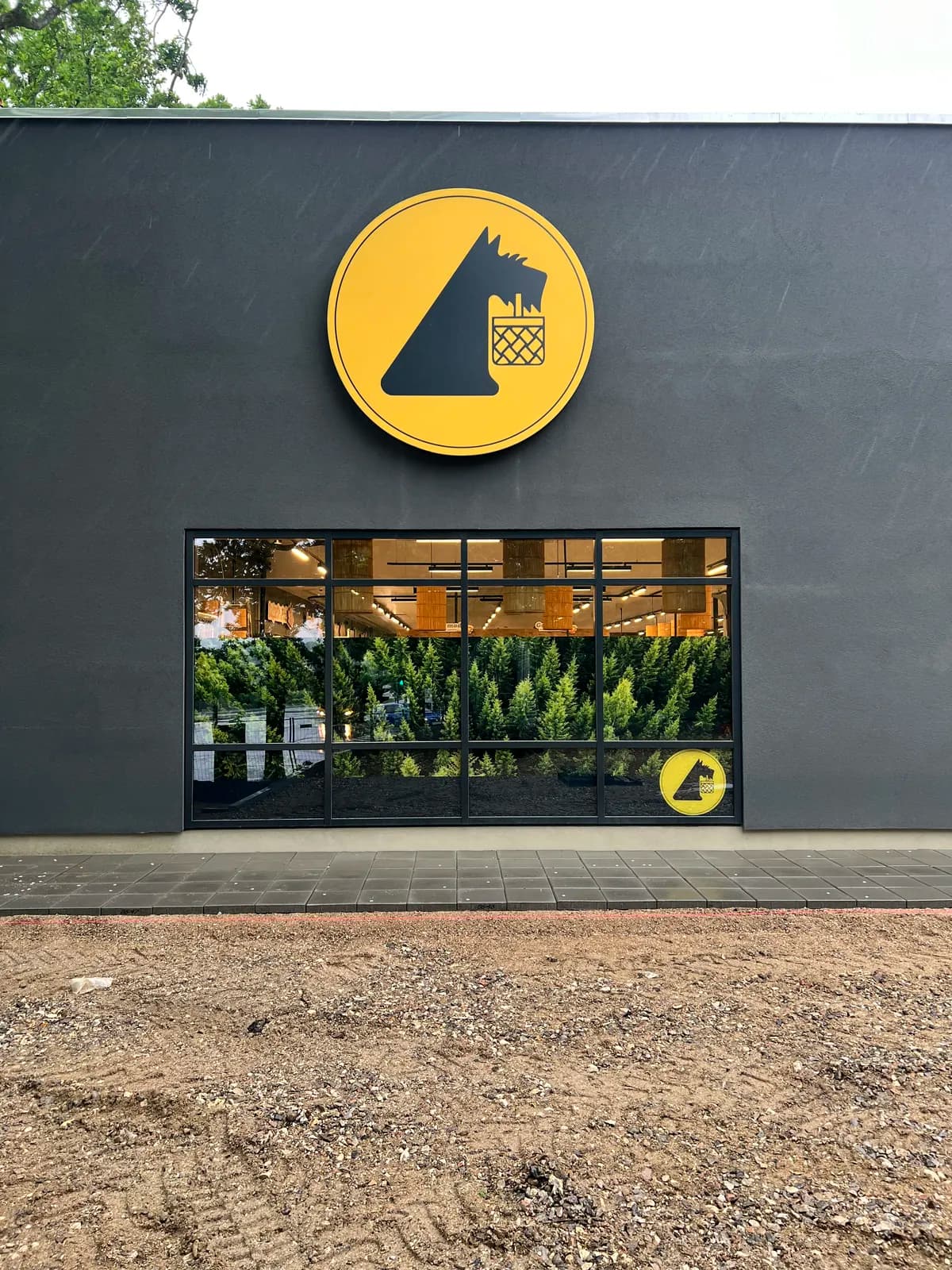 Rundt facadeskilt med Netto-logo monteret på mørk facade