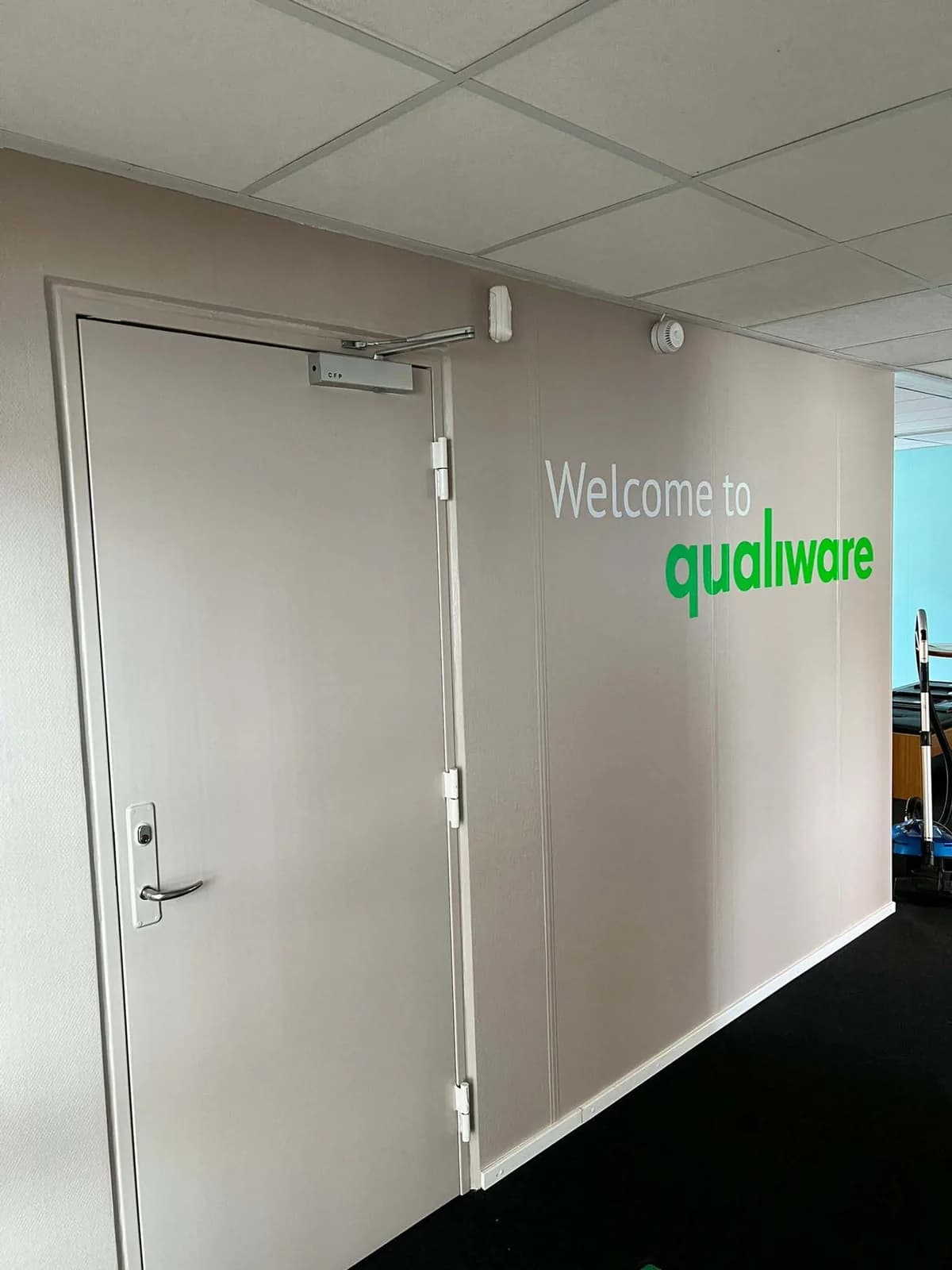 Dørfolie med velkomsttekst hos QualiWare
