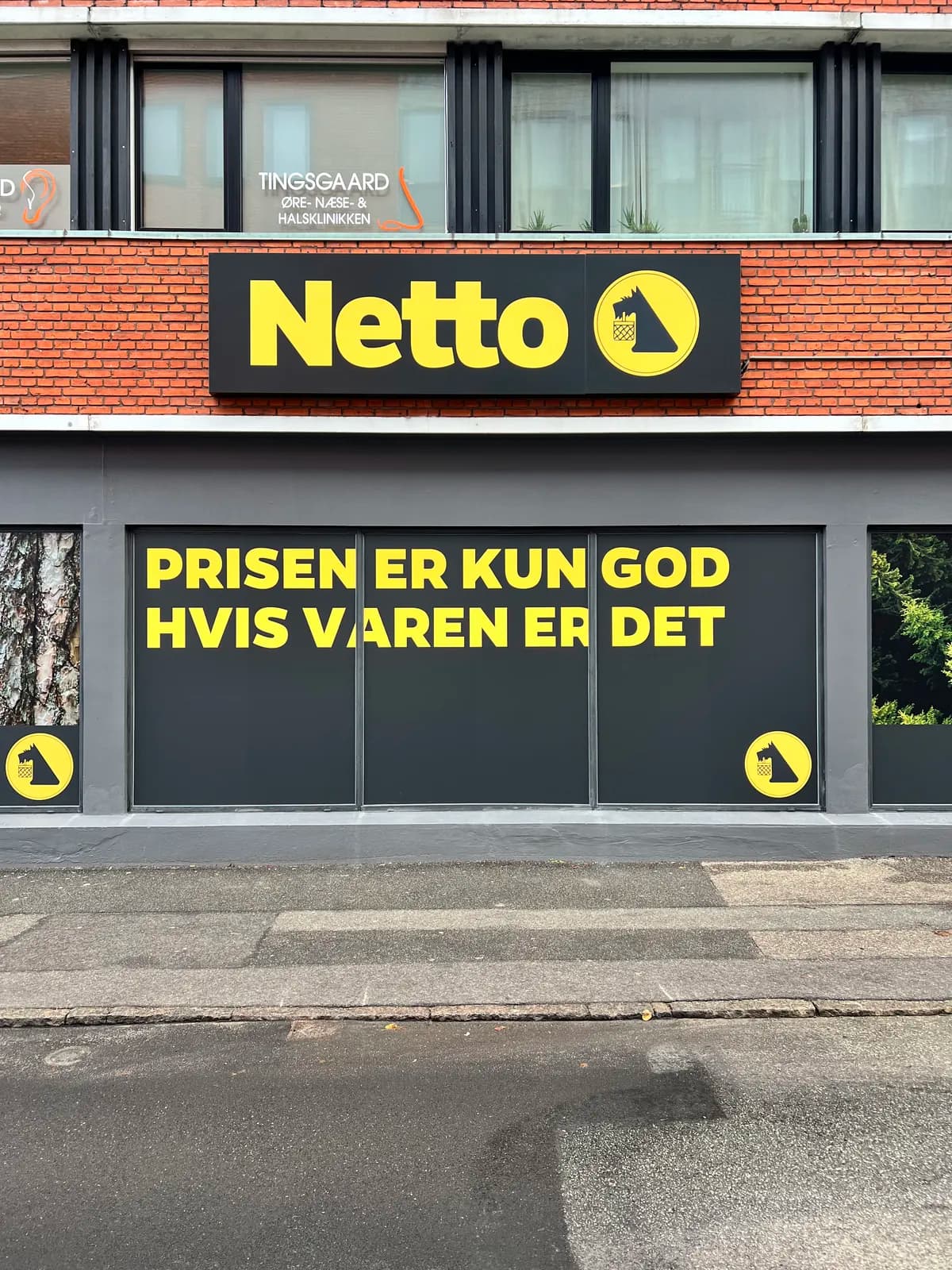 Vinduesfolie med kampagnetekst og Netto-logoskilt på facaden af Netto