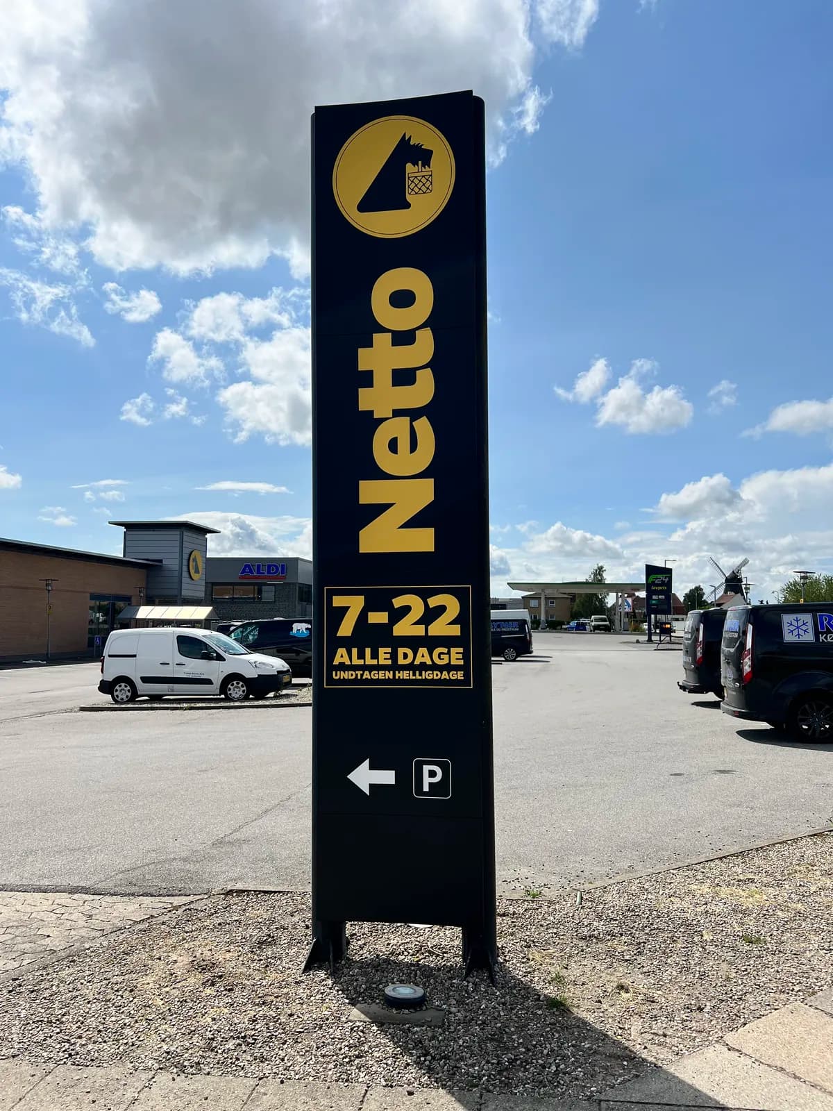 Pylon med logo, åbningstider og parkeringshenvisning ved Netto