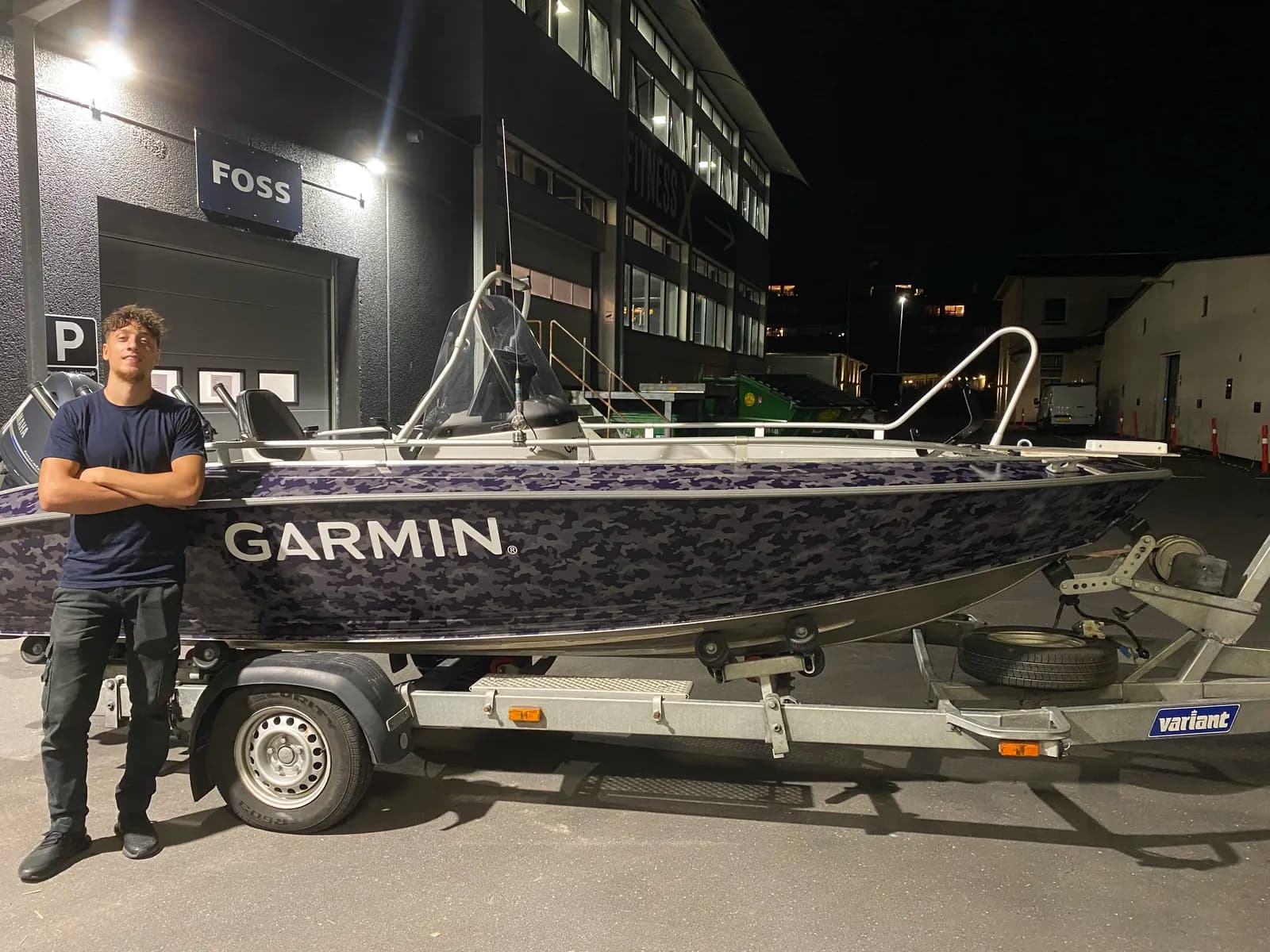 Montør ved den færdigfolierede Garmin-båd i camouflagefolie efter aflevering