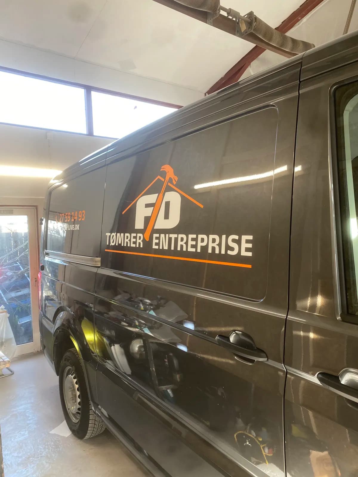 Bildekoration med logo og kontaktoplysninger til FD Tømrer Entreprise monteret på varevogn